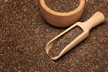 Organic natural chia seeds, wooden scoop and bowl close-up