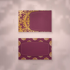 Presentable business card in burgundy color with Indian gold ornaments for your contacts.