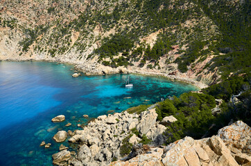 Fototapeta premium idyllic stone beach with turquoise water and a sailboat in majorca, spain 2