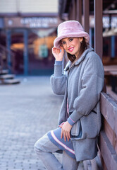 beautiful caucasian girl walks in the city in winter in a fur coat and hat
