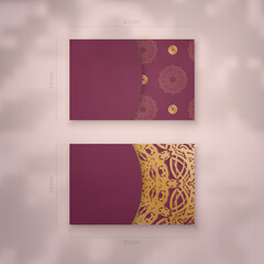 Presentable business card in burgundy color with vintage gold ornament for your contacts.