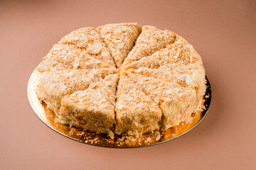 Cake Napoleon of puff pastry and custard bakery. Closeup on brown background