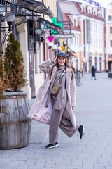 beautiful caucasian girl walks in the city in winter in a fur coat and hat