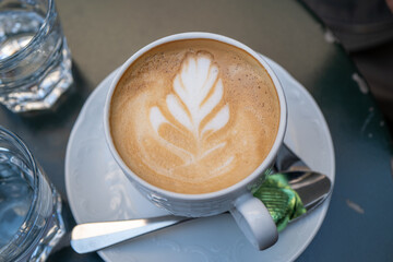 Latte with design on white cup in Cafe, Schwarzenbach Kolonialwaren, Zurich, Switzerland