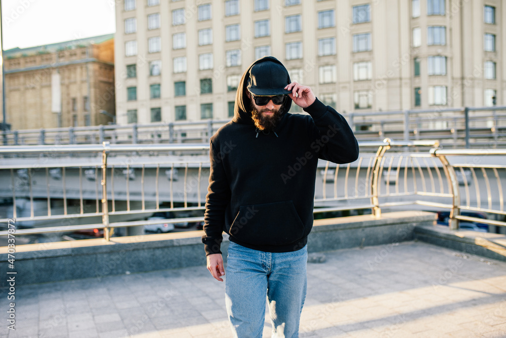 Sticker City portrait of handsome hipster guy wearing black blank hoodie with space for your logo or design. Mockup for print