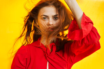 cheerful woman in red dress posing in nature yellow cloth