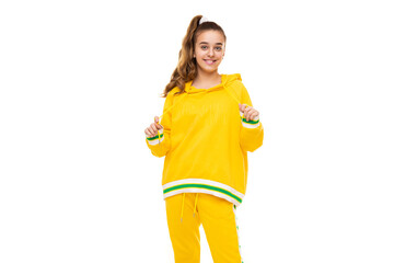 Beautiful funny happy wonderful smiling cute girl with dark hair with ponytail in stylish yellow tracksuit with green stripes isolated on white background with empty space for text