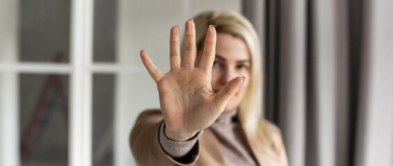 Portrait of young woman making stop sign with her hand.