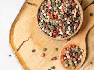 Pepper mix. Black, red, green, white peppercorns spices, Mix of different peppers in a wooden spoon