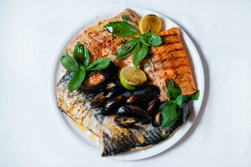 Baked fish with mussels and lime. Healthy seafood dish.