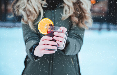 female hands holding cup of traditional christmas mulled wine