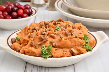 Bowl of mashed sweet potatoes with glazed pecans