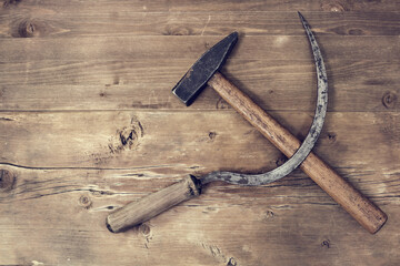 Sickle and hammer on wooden surface