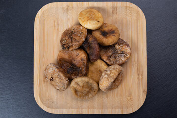 dried figs in a wooden plate. organic fruits for a healthy lifestyle. vegetarian food