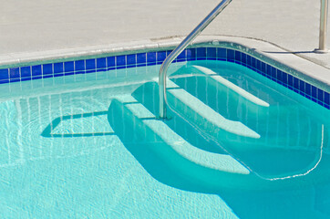 Swimming pool with stair at hotel close up