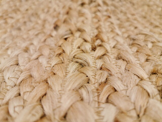 Handmade jute carpet, the texture of a jute carpet. Natural jute, woven by hand. The rug is hand-woven from natural jute fibers. Carpet made of environmentally friendly materials, blurred background