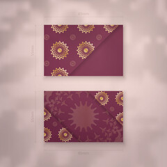 Visiting business card in burgundy color with abstract gold ornament for your contacts.