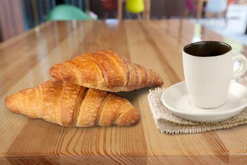 Freshly baked croissants, a cup of coffee on the desk