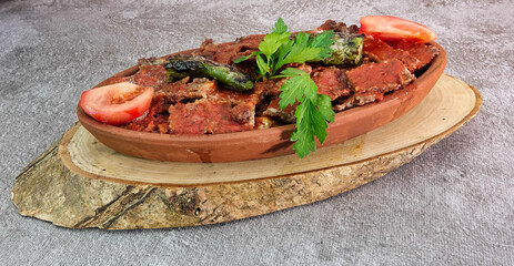 close up of Turkish Iskender Kebap garnished with roasted vegetables on a wooden tray - Turkish, Food Kebab