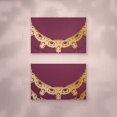 Visiting business card in burgundy color with Indian gold ornaments for your contacts.