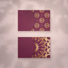 Visiting business card in burgundy color with mandala gold ornament for your brand.