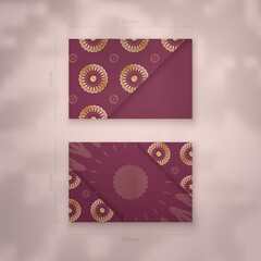Visiting business card in burgundy color with mandala gold ornament for your brand.