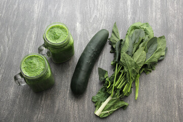 Green juice served in a mason jar with vegetables such as cucumber, chard, spinach, lemon and fruits for a healthy and nutritious breakfast
