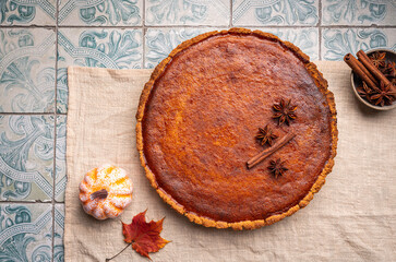 American pumpkin pie with cinnamon on tile background, top view