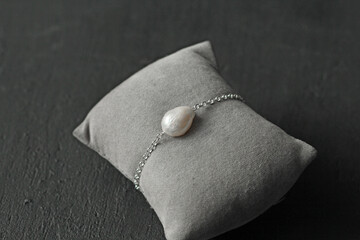 Natural Kasumi White pearls bracelet on silver chain. Bracelet made from Natural Kasumi pearls. Handmade pearls bracelets on black modern background. Designer jewelry, bracelet with kasumi pearl