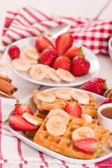 Waffles with strawberries, bananas and honey.