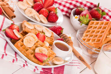 Waffles with strawberries, bananas and honey.