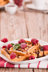 Waffles with raspberries and chocolate cream.