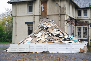 Demolition in progress of derelict house on construction building site