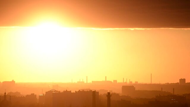 Sunset timelapse over a city with factories and protruding pipes