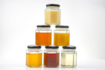 Hexagonal jars with different types and colors of fresh flower honey. vitamin food for health and...
