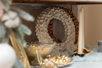 Shiny painted white and golden Christmas wreaths on decorated cupboard. Festive vibes, Happy new year, winter holidays