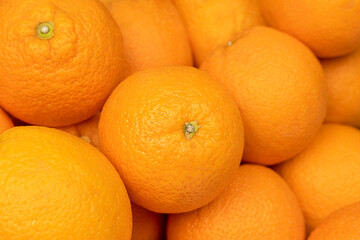 Background image: heaped fresh ripe large oranges from the new harvest