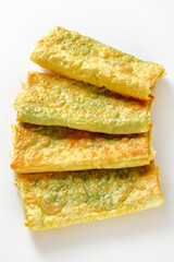 burritos with cheese and greens filings on a white