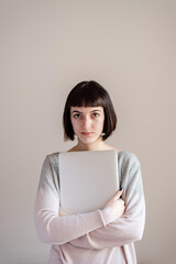Portrait of young student, she is holding files and laptop