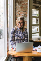 Woman sitting in coffee shop using laptop