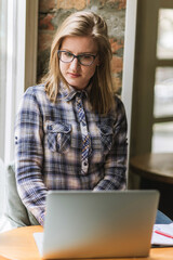 Woman sitting in coffee shop using laptop