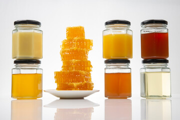 Hexagonal jars with different types and colors of fresh flower honey. vitamin food for health and...