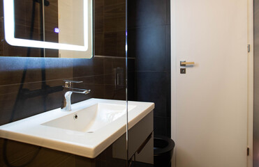 Fototapeta na wymiar modern bathroom with dark furniture and spotlights