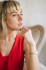 Portrait of beautiful blond young woman wearing red dress