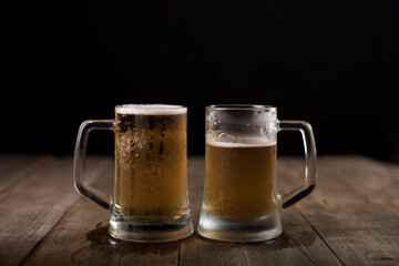 Two beer mugs at a wooden table
