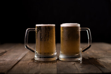 Two beer mugs at a wooden table