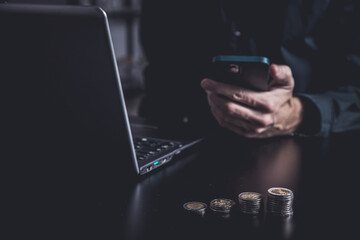 Businessman using a smartphone and notebook in a moddy office
