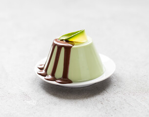 Vegan Avocado creamy pudding with chocolate sauce on a platte on a light gray background