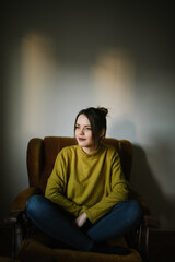 Obraz premium Portrait of a young woman sitting in armchair