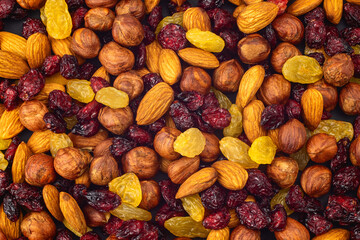 Mixed dried fruits background. Healthy snacks. Almonds, raisins, hazelnuts, cranberries. Assorted...